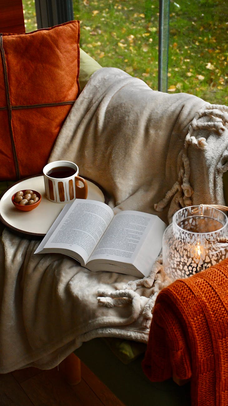 cozy autumn reading corner with blanket and mug